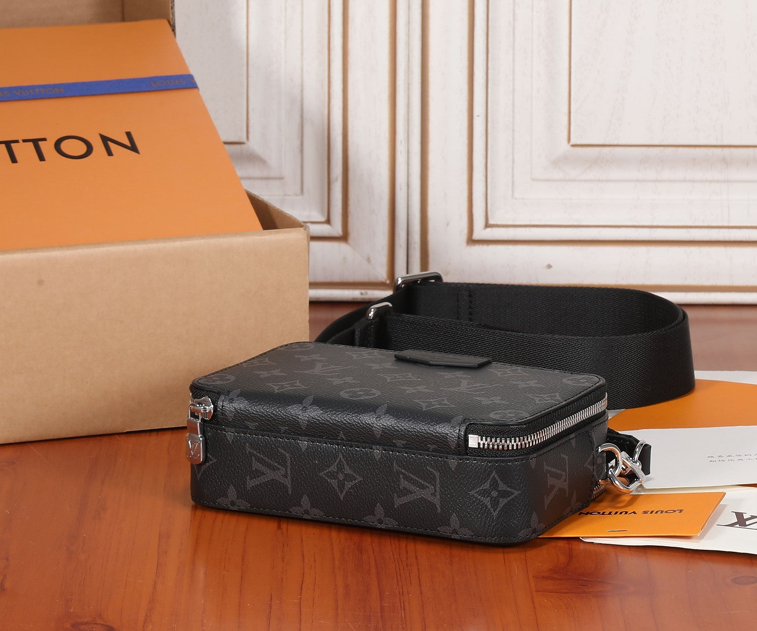 Louis Vuitton monogram crossbody bag with zipper top and wide black shoulder strap