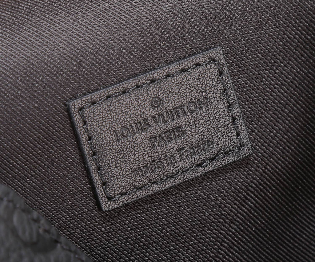 Louis Vuitton Paris logo leather patch on black textured crossbody bag interior
