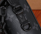Crossbody bag close-up of black chain link strap and monogram canvas