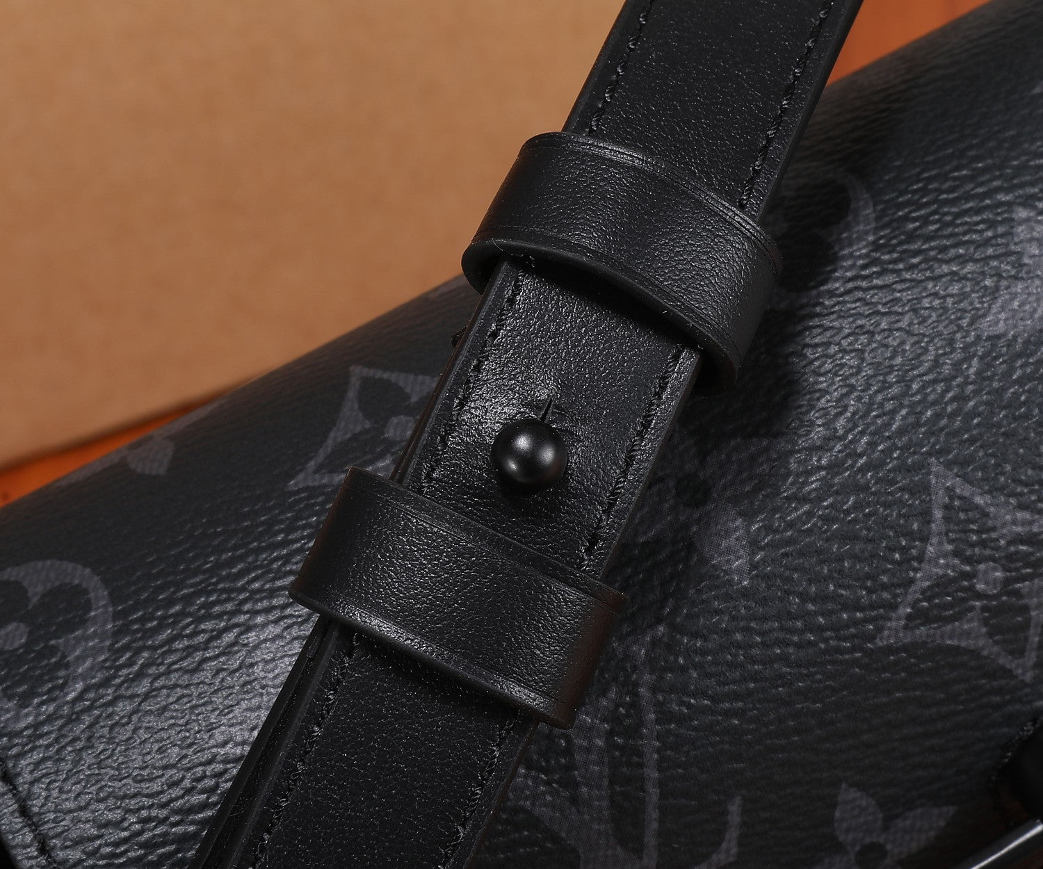 Crossbody bag strap attachment with black leather buckle and stud