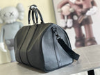 Leather duffle bag in dark blue with curved top handles and side wrist strap