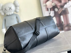 Leather duffle bag in dark blue with zipper, crossbody strap, and front buckle detail