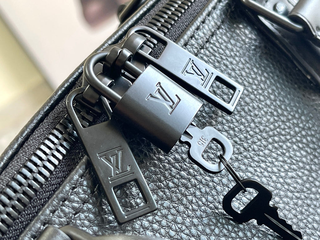 Leather bag hardware close-up with metal zipper pulls and LV-style accents