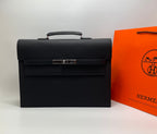 Black leather Hermes bag with top handle and front flap closure