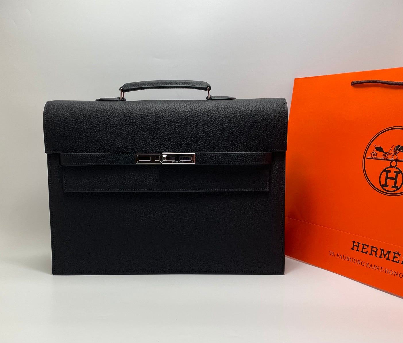 Black leather Hermes bag with top handle and front flap closure