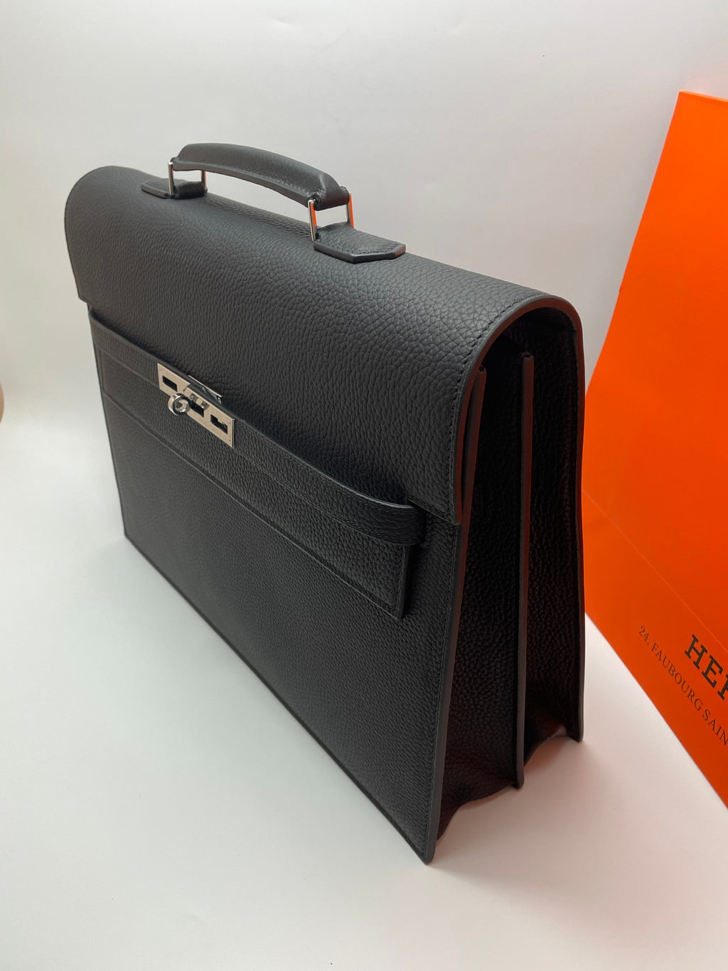 Black leather Hermes bag side view with strap detail and open edge