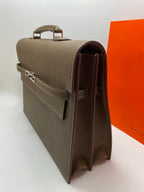 Taupe leather briefcase side profile with hinged clasp and rear handle strap