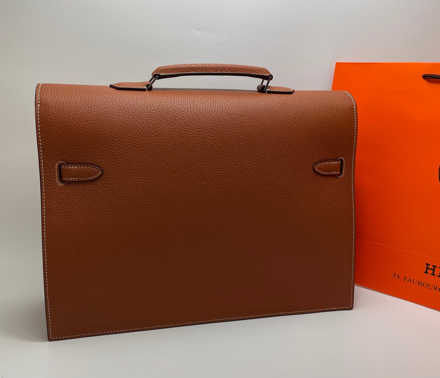 Hermes brown leather briefcase back view with corner handles and stitched flap