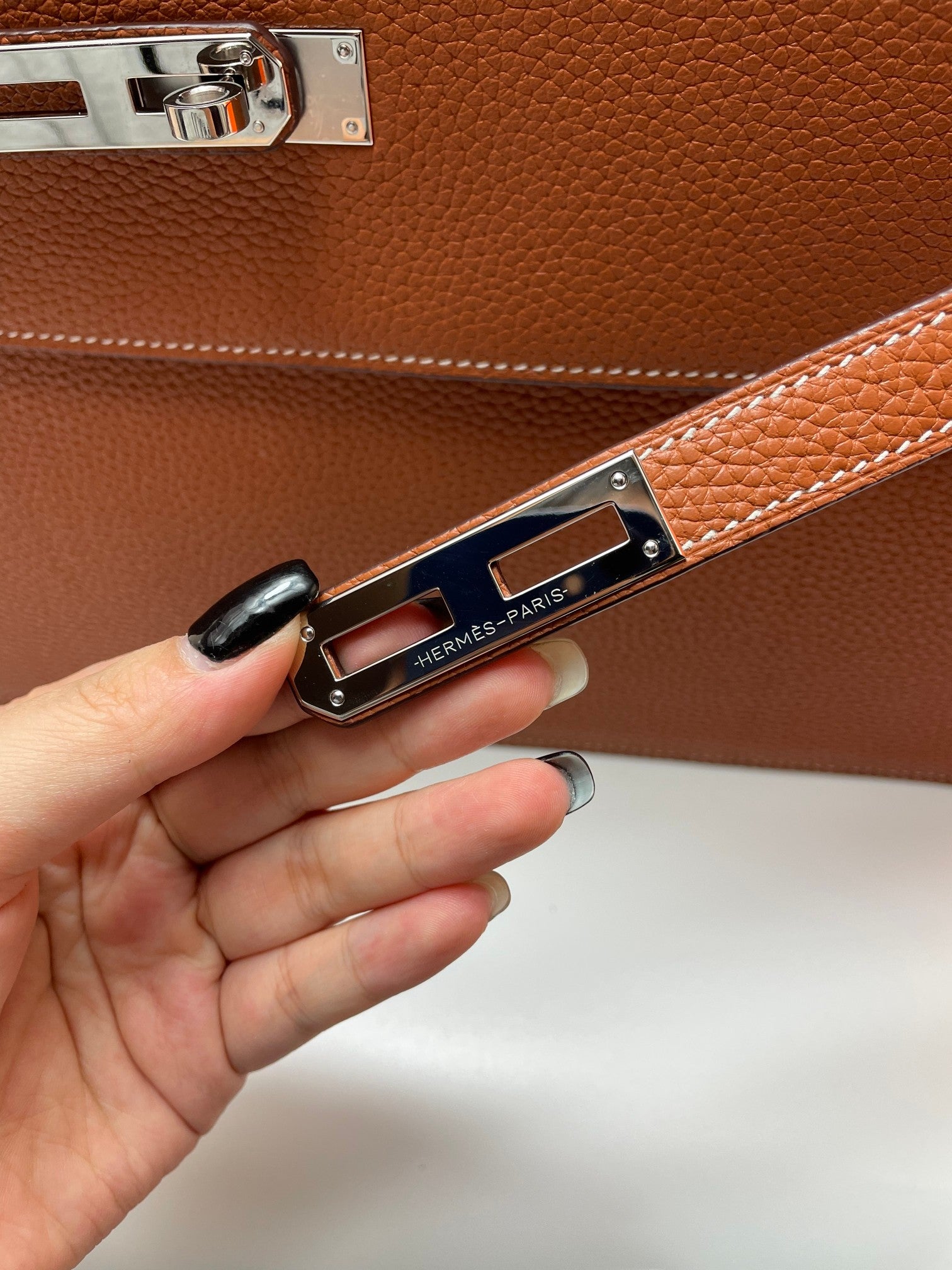 Hermes brown leather briefcase close-up of front hardware and clasp plate