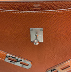 Hermes brown leather briefcase close-up of front lock, hardware, and stitching
