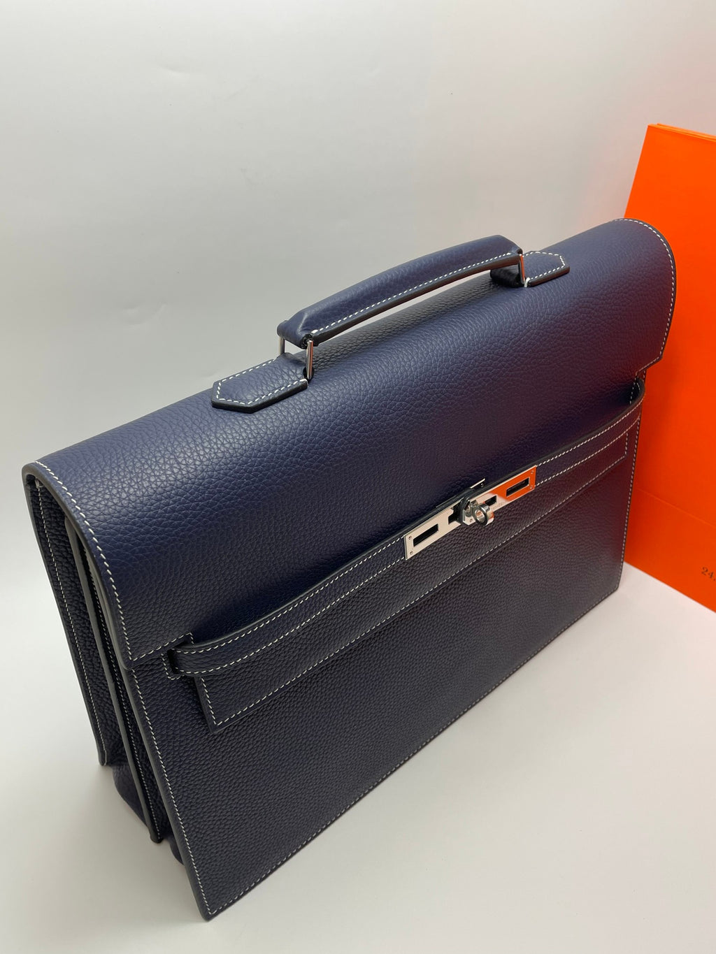 Hermes navy leather briefcase with top handle and front latch, side view