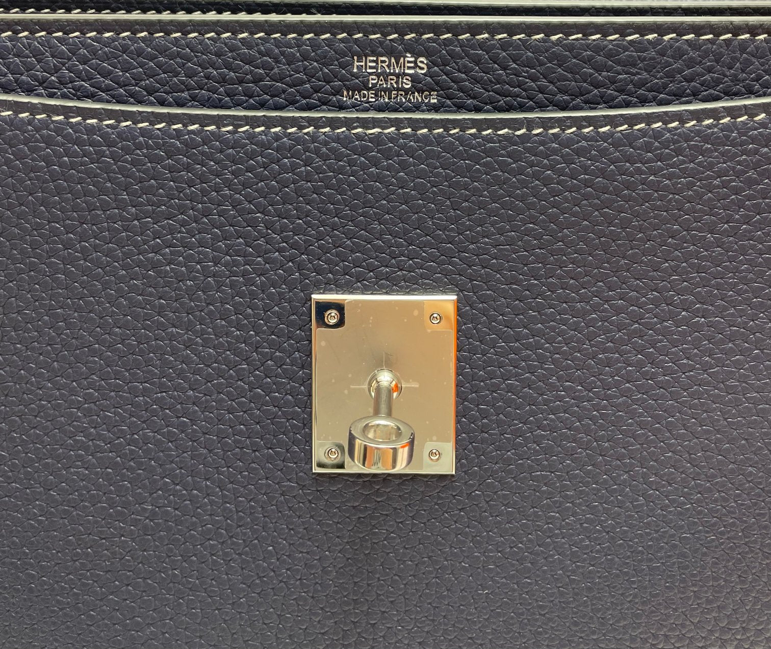Gold-tone lock plate with Hermes Paris engraving on navy leather bag