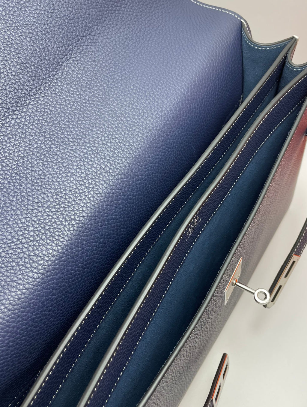 Navy leather bag side panel with stitched trim and zipper hardware