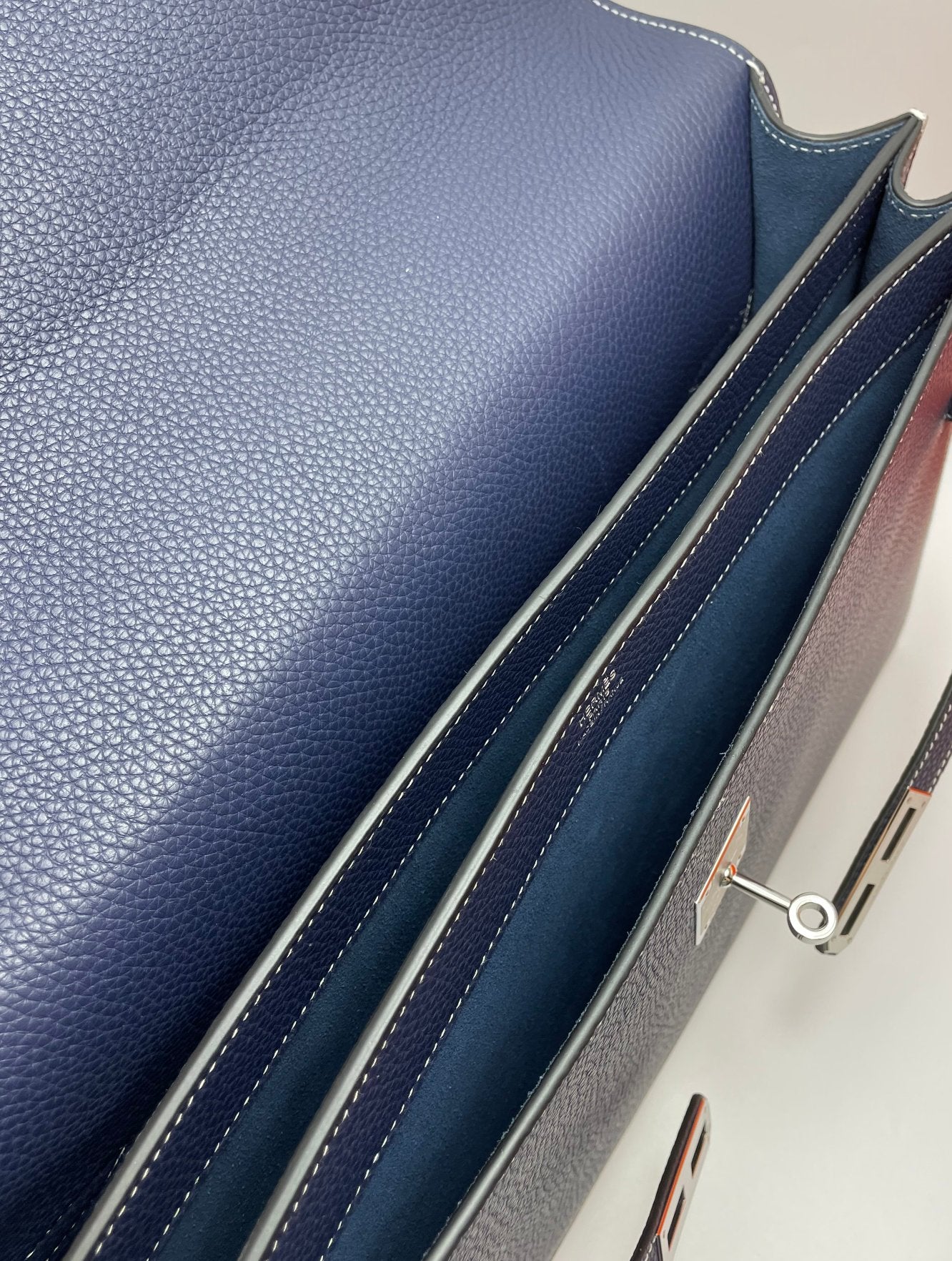 Navy leather bag side panel with stitched trim and zipper hardware