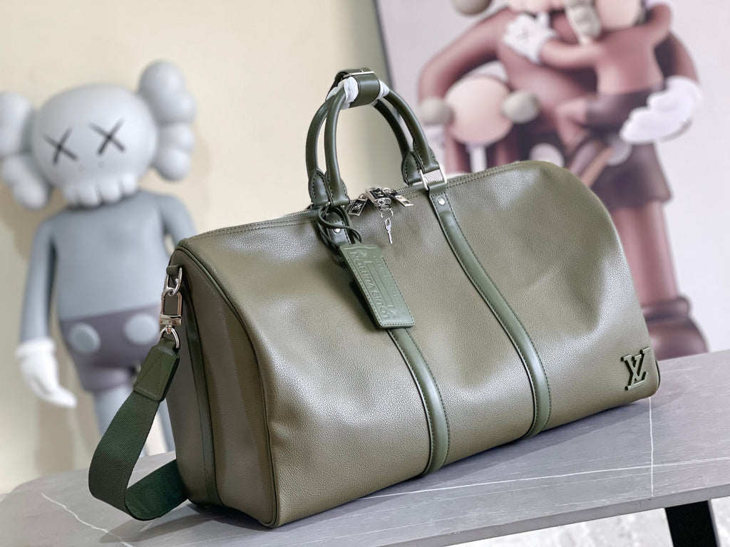 Olive green leather duffel bag with top handle and crossbody strap