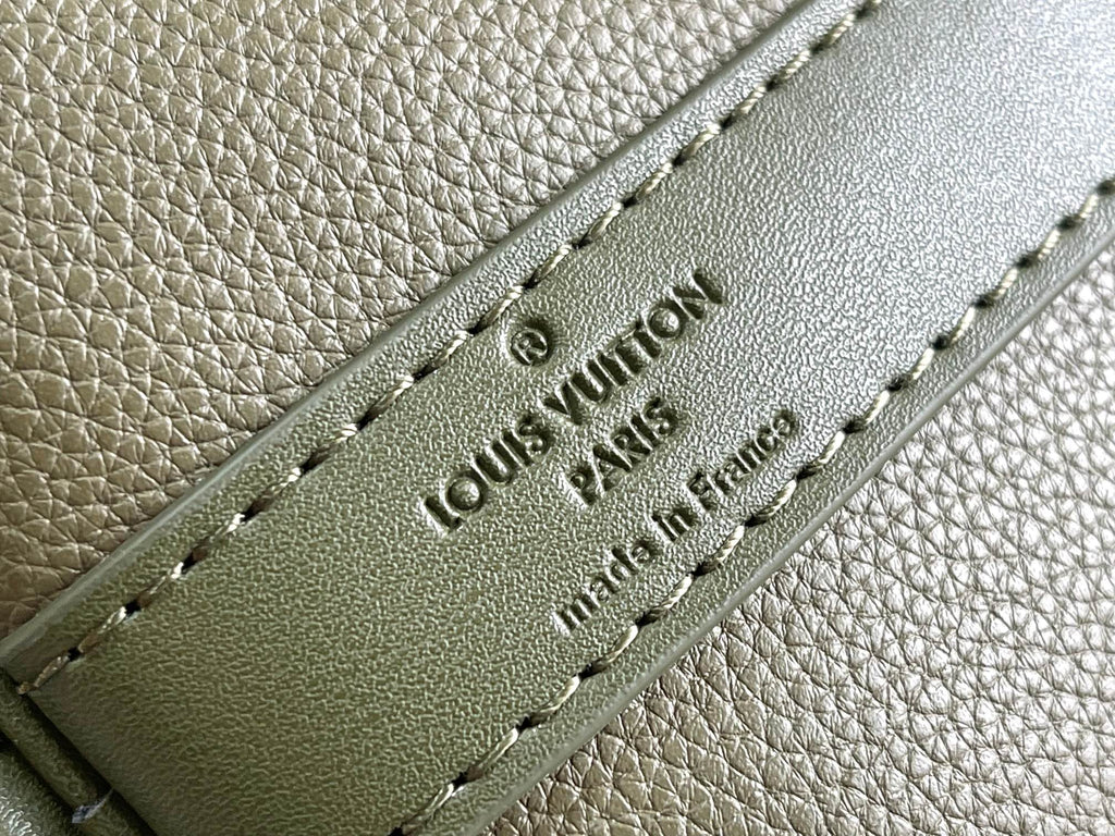 Men's Louis Vuitton leather tab detail with embossed logo on olive green duffel