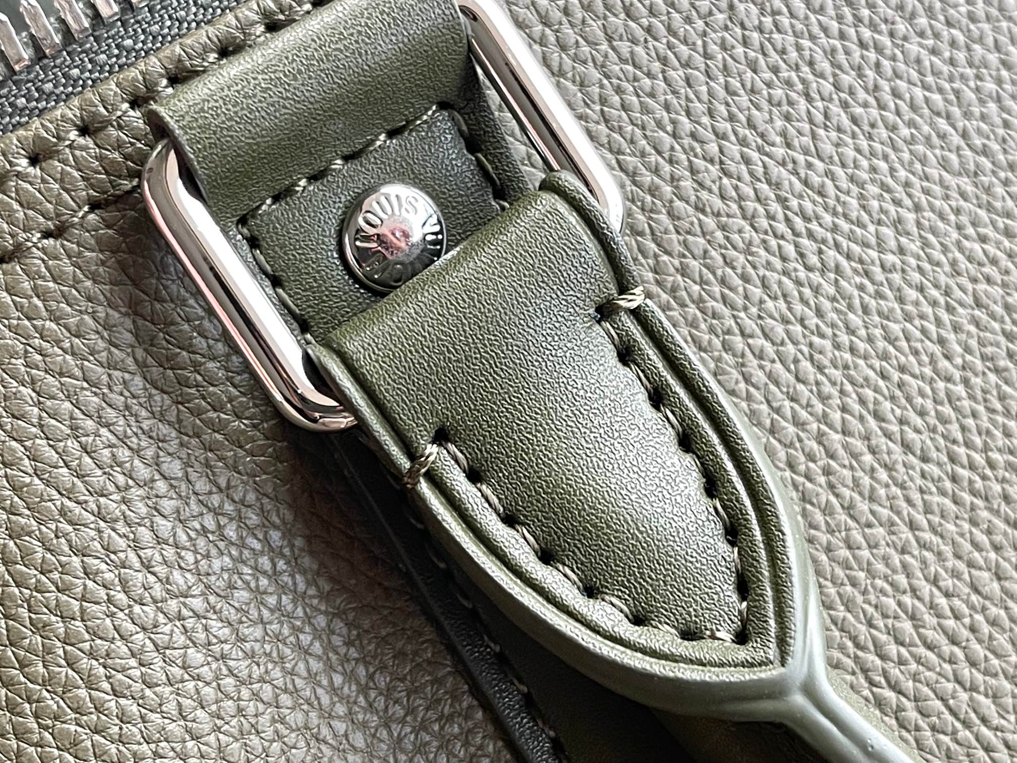 Men's Louis Vuitton duffel bag strap loop with stitched leather panel on olive green