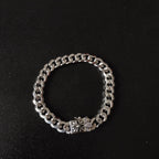 Silver chain bracelet with floral charm at center, chunky link chain