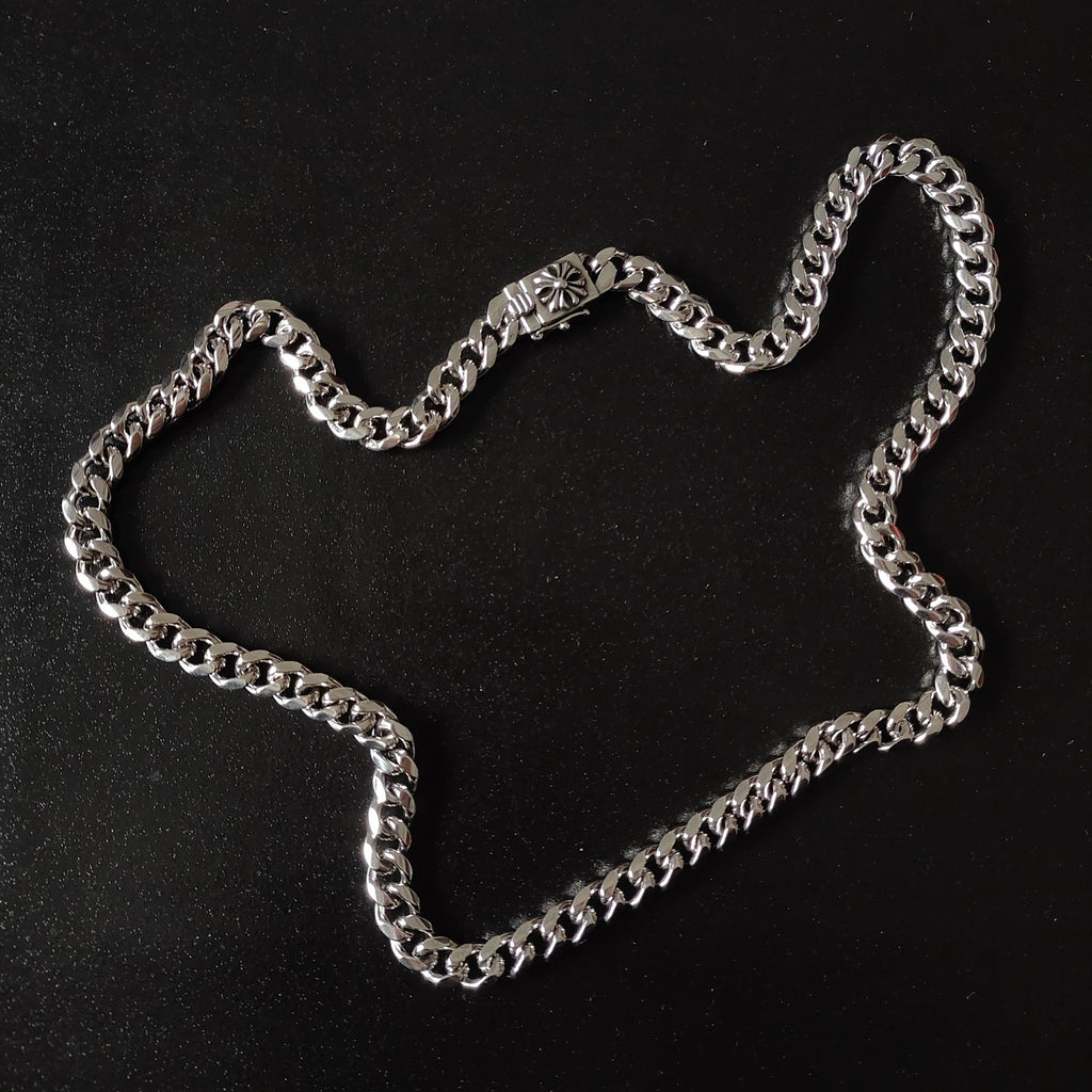 Silver chain necklace with chunky links and floral charm centerpiece