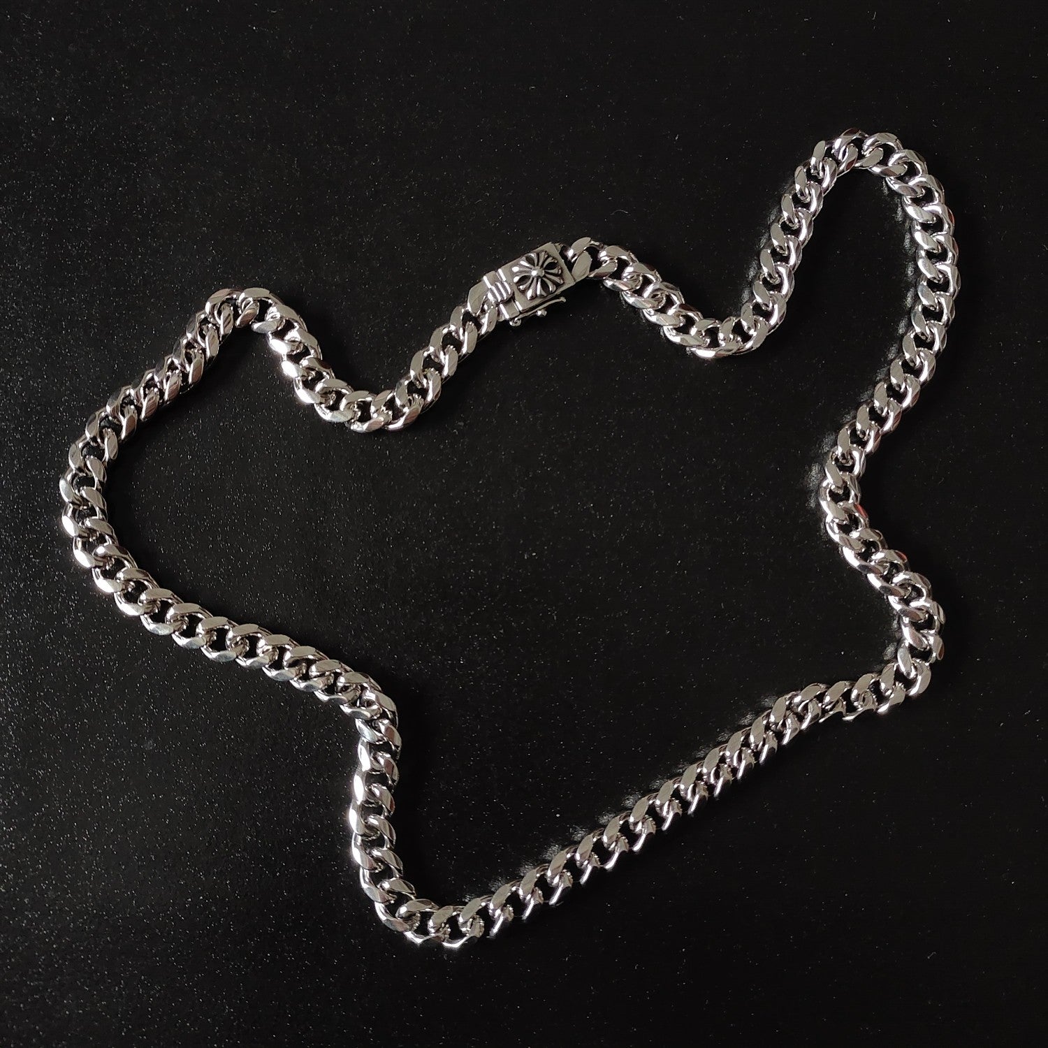 Silver chain necklace with chunky links and floral charm centerpiece