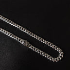 Silver chain necklace close-up, floral charm link centerpiece