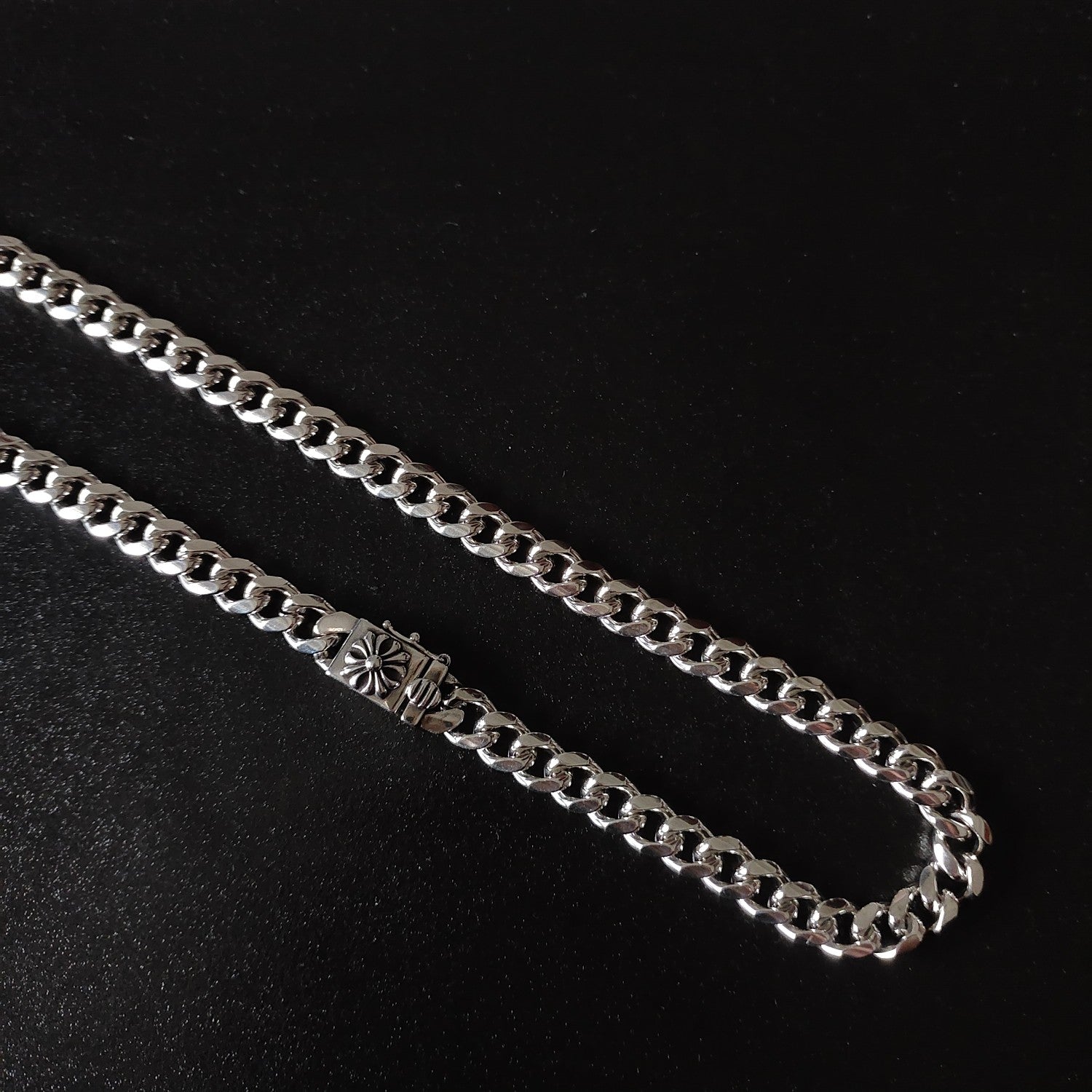 Silver chain necklace close-up, floral charm link centerpiece