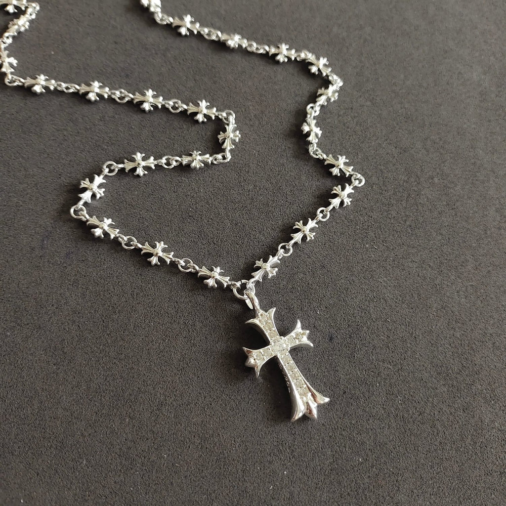Silver cross pendant necklace, close view of chain and cross charm