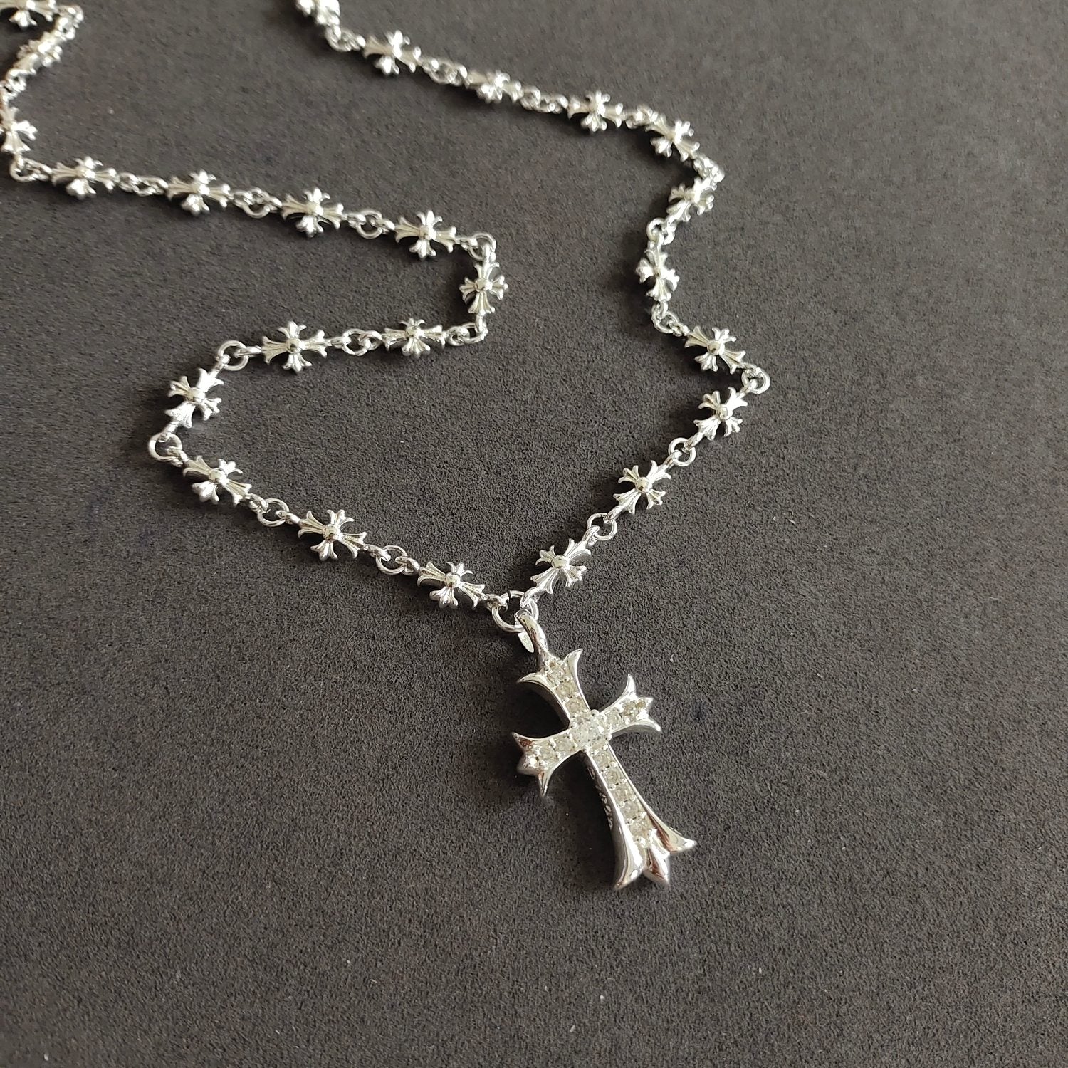 Silver cross pendant necklace, close view of chain and cross charm