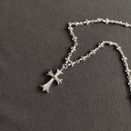 Silver cross pendant necklace with small star-flower chain links