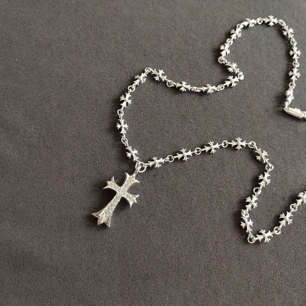Silver cross pendant necklace with dangling cross charm and floral chain