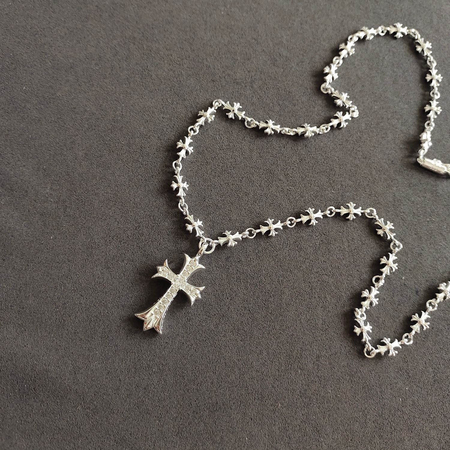 Silver cross pendant necklace with dangling cross charm and floral chain