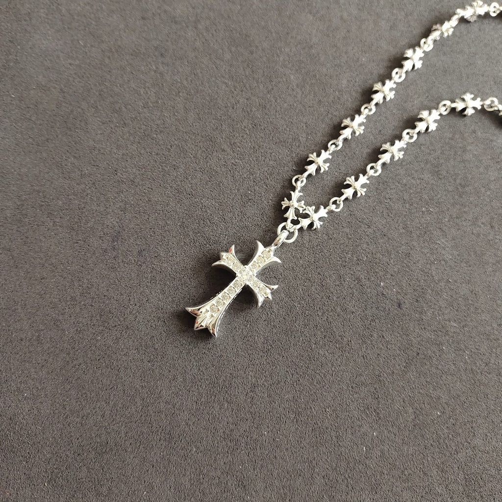Silver cross pendant necklace with cross charm on floral chain links