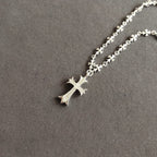 Silver cross pendant necklace with cross charm on floral chain links