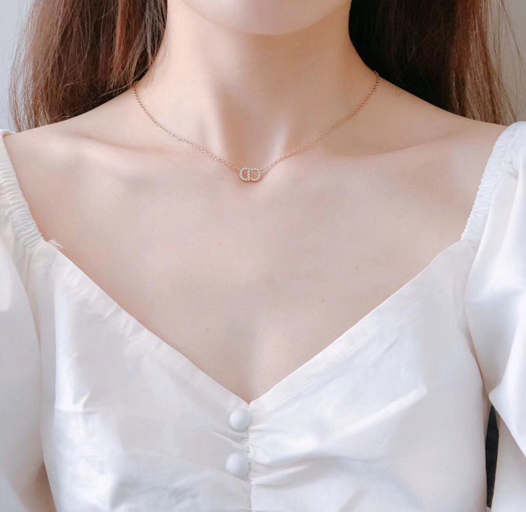 Gold-tone pendant choker necklace with small interlocking motif