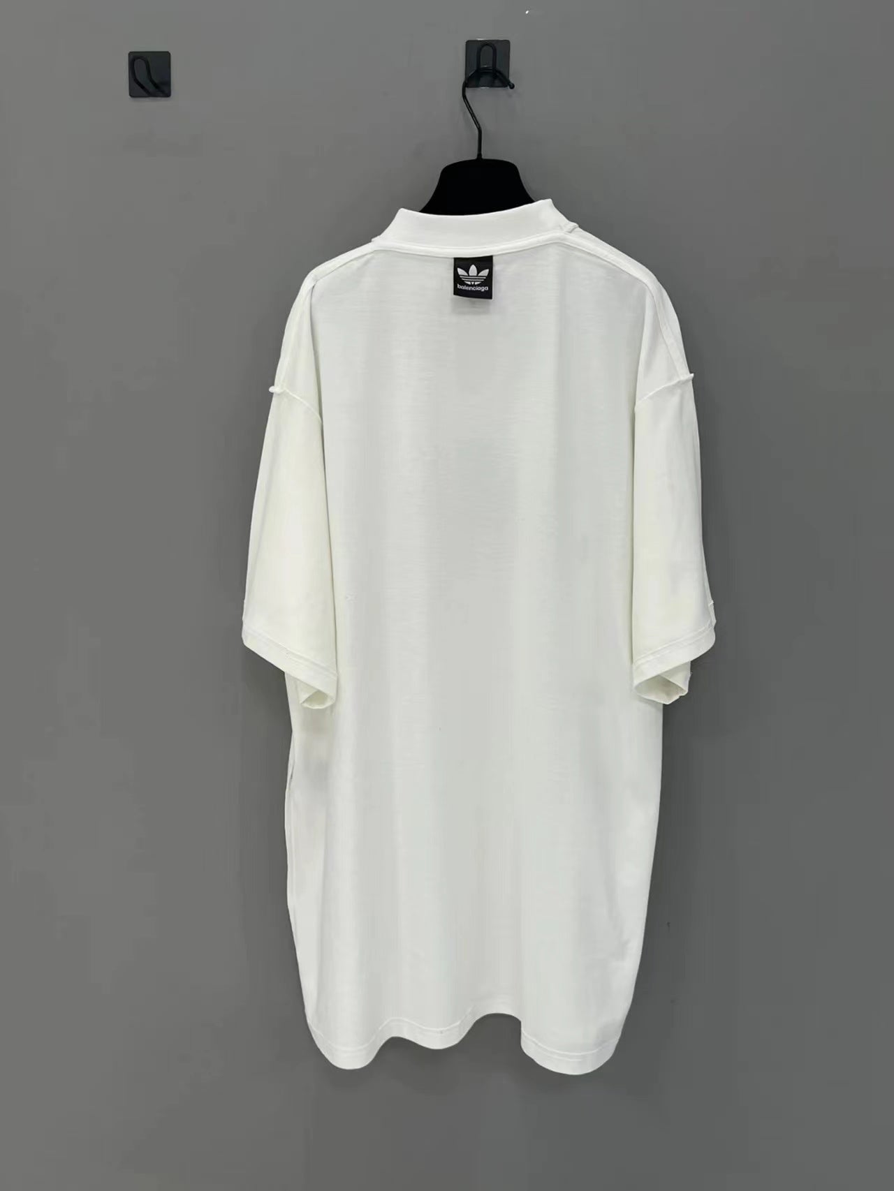 White short-sleeve T-shirt back view with Balenciaga logo patch at collar
