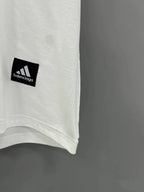 Close-up of white T-shirt hem with small Balenciaga logo patch