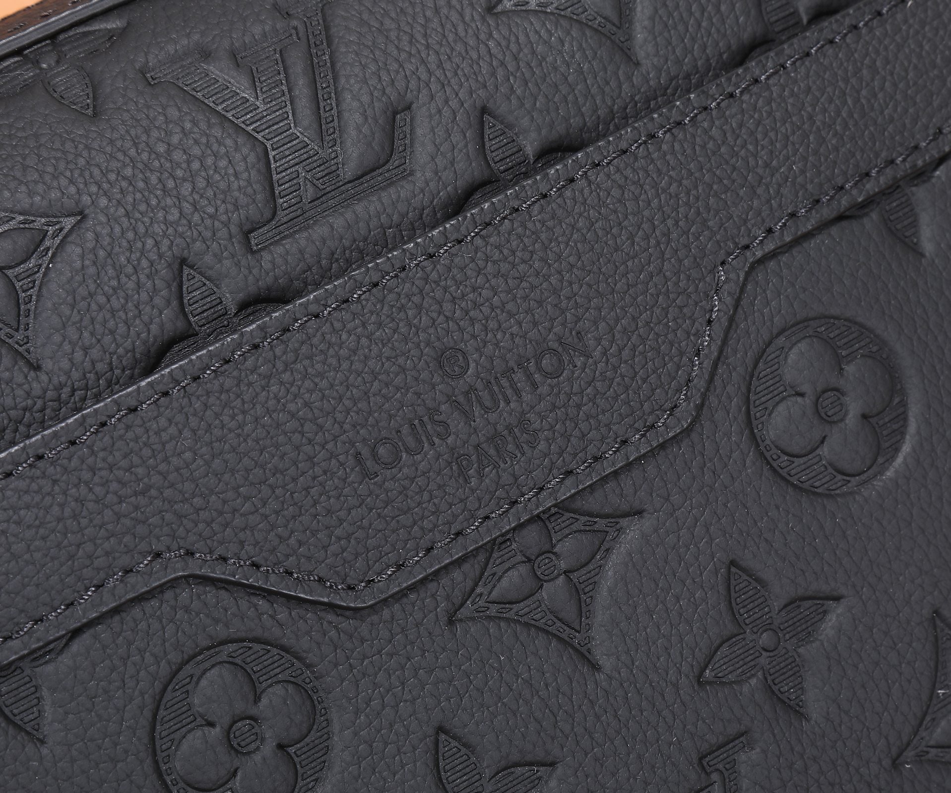 Black embossed monogram crossbody bag seam and logo stamp detail
