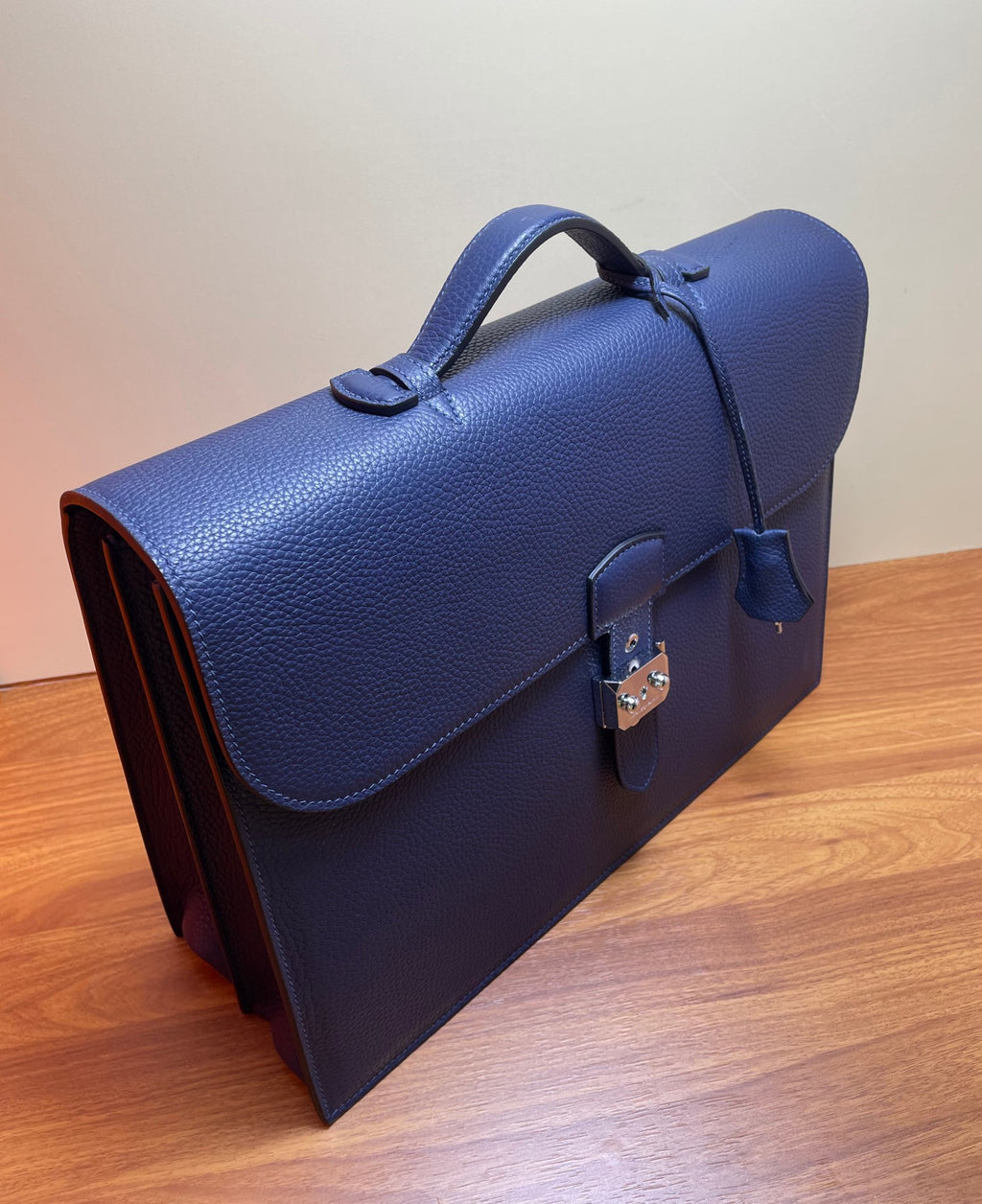 Hermes briefcase bag in textured blue leather, side view with turn-lock and strap