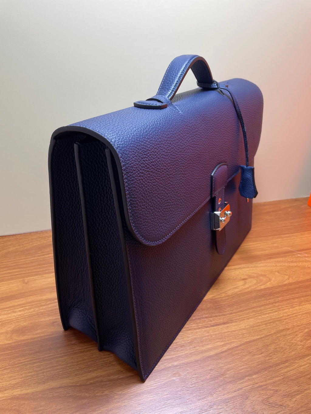Hermes briefcase bag in textured blue leather, corner view with handle and lock