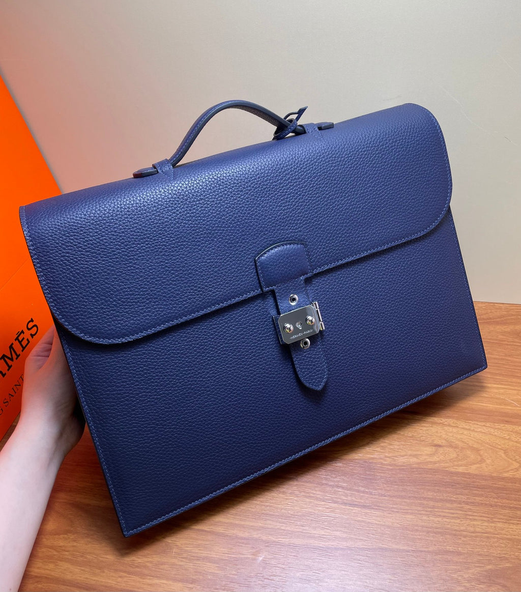 Hermes briefcase bag in textured blue leather with front flap and turn-lock close-up