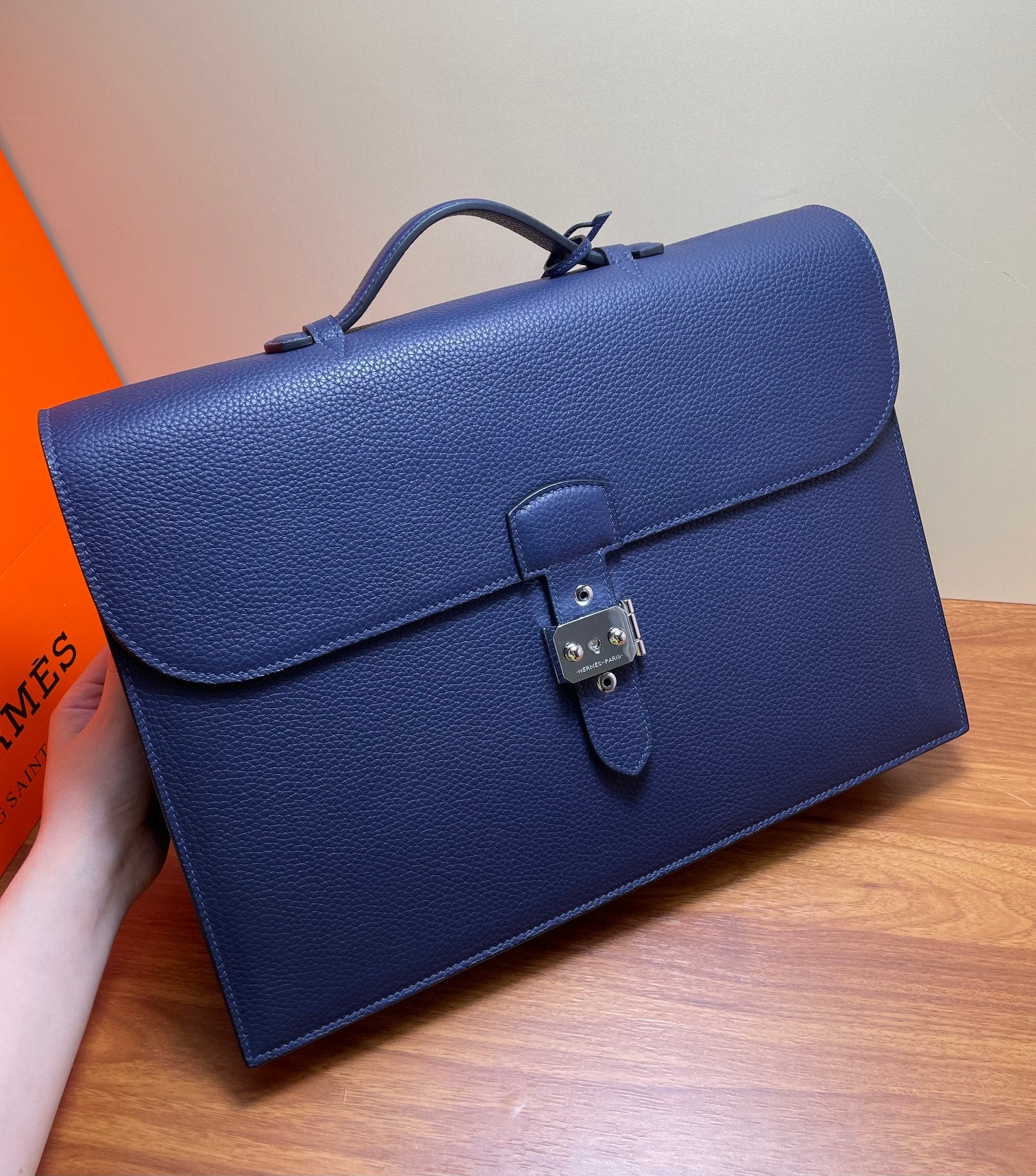 Hermes briefcase bag in textured blue leather with front flap and turn-lock close-up