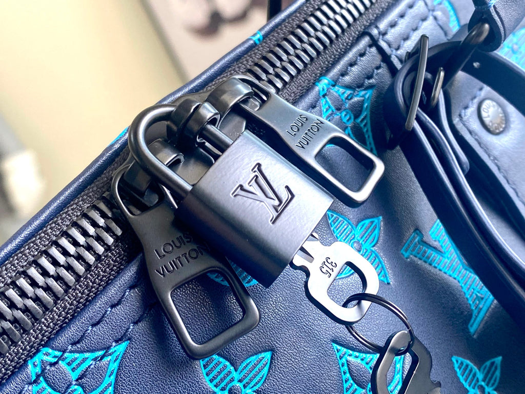 Teal monogram bag zipper pull with metal rings and Louis Vuitton logo