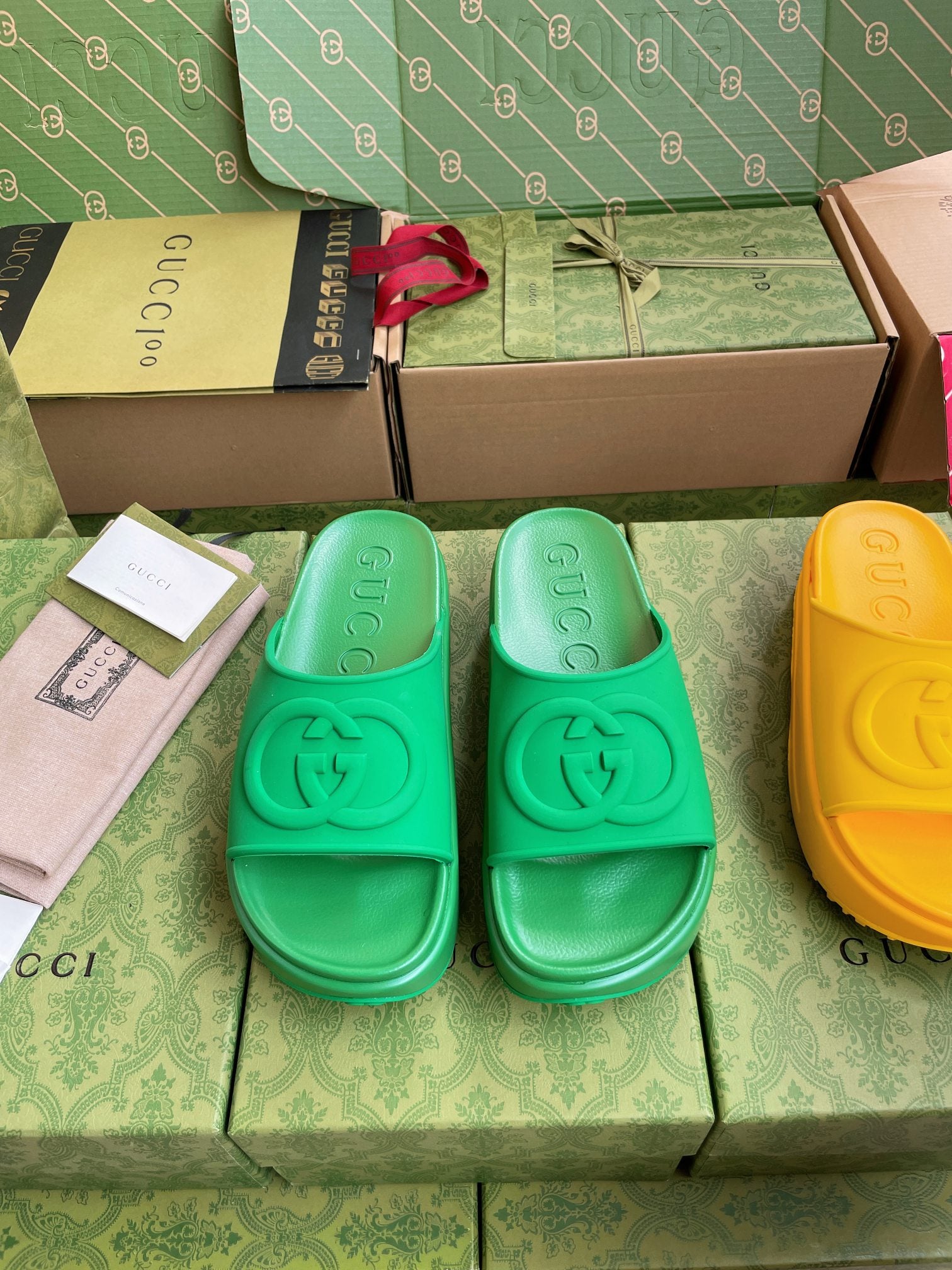 Gucci slide sandals in bright green with embossed logo footbed.