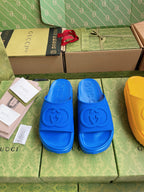 Gucci slide sandals in royal blue with embossed logo footbed.