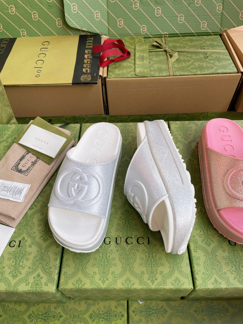 Emossed logo slide sandals in white, glittery texture on wide straps