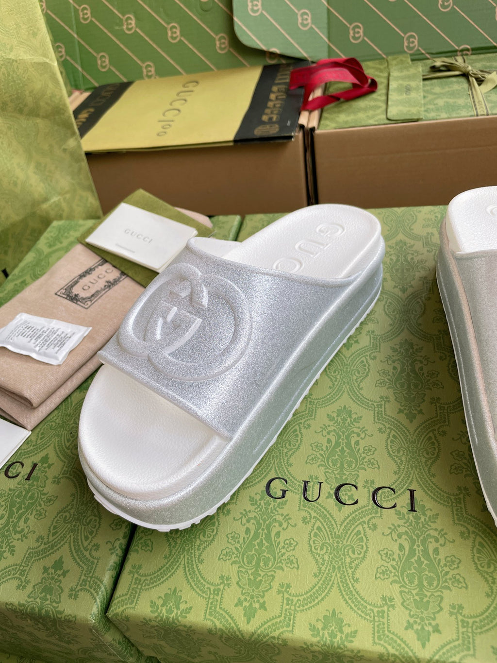 White logo slide sandals with embossed interlocking emblem on single wide strap