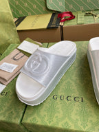 White logo slide sandals with embossed interlocking emblem on single wide strap