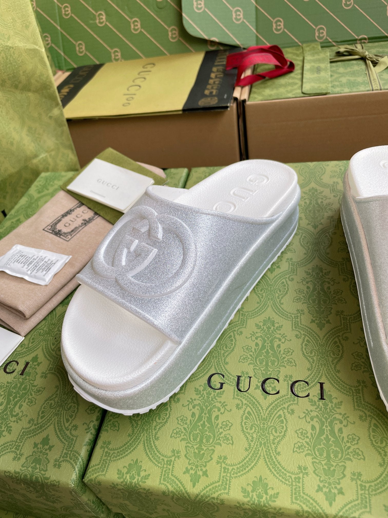 White logo slide sandals with embossed interlocking emblem on single wide strap