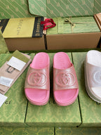 Pink logo slide sandals with embossed interlocking emblem on wide straps
