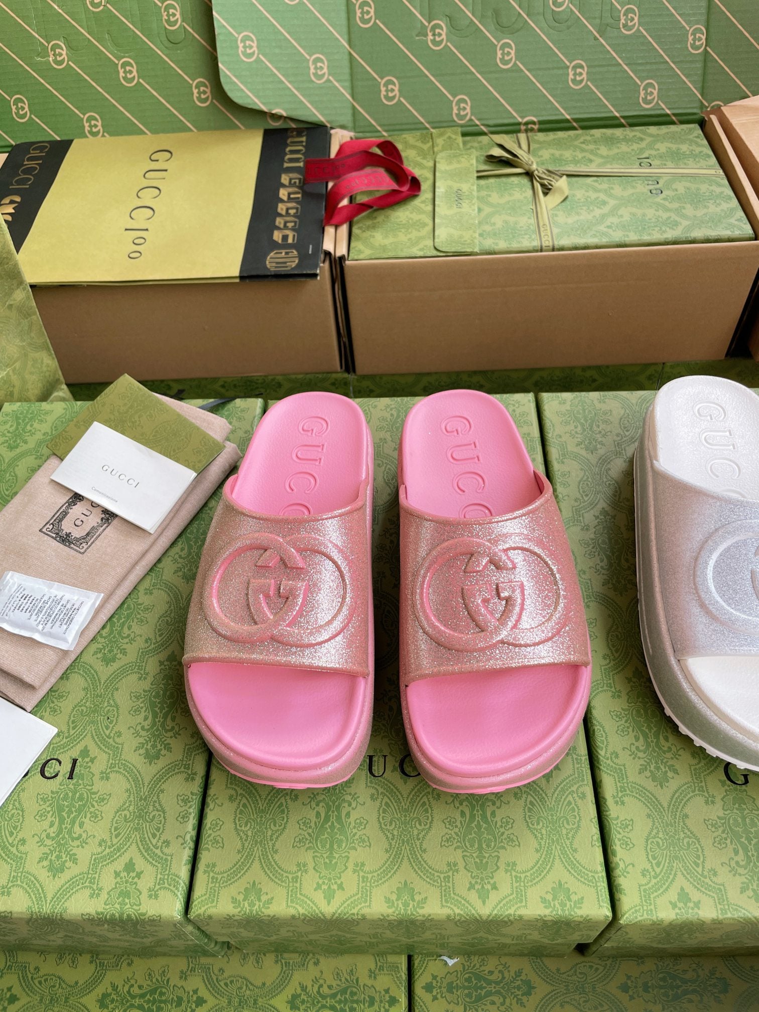 Pink logo slide sandals with embossed interlocking emblem on wide straps